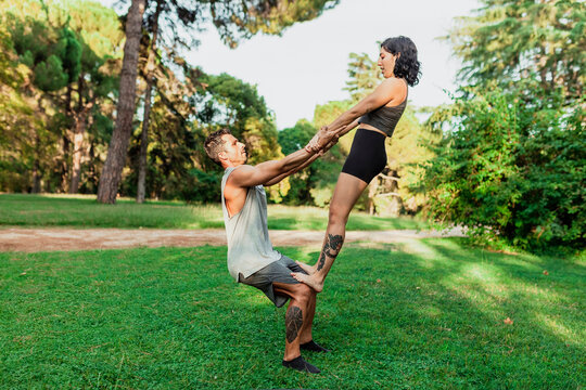 Male and female athletes practicing acroyoga in park
