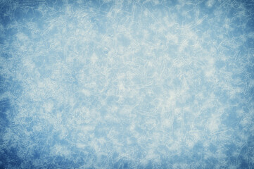 White openwork pattern of ice veins in the haze and frost with illumination on a muted blue background with a grayish tint. Background
