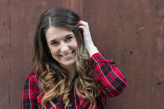 Portrait of smiling young woman wearing red plaid shirt