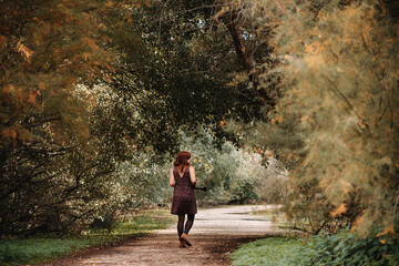 Young woman walking on footpath amidst plants in forest
