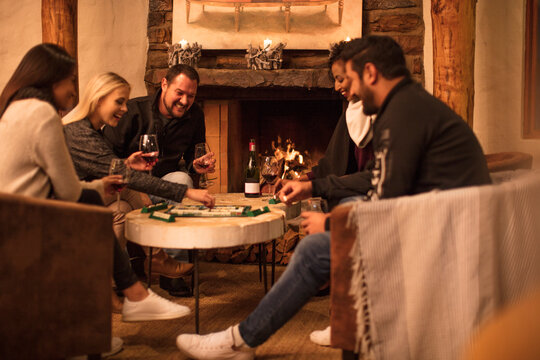 Friends sitting together at table playing a game