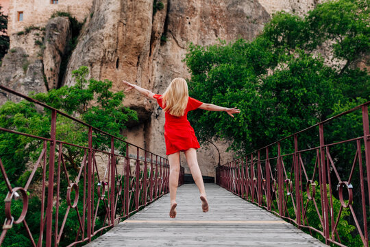 Ballerina walking and dancing over Saint Paul Bridge in Cuenca, Spain