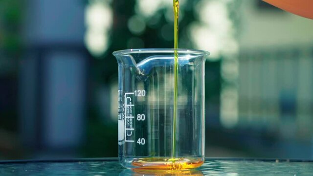  pouring orange emulsion to beaker bokeh background slow motion 100fps