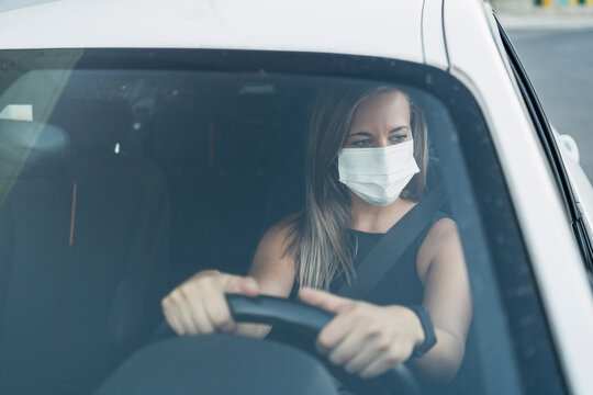 Woman in car with protective mask