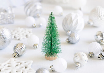 Green toy Christmas tree with white and silver Christmas decorations