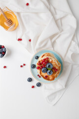 Tasty pancakes with fresh blueberry, raspberries and honey. Healthy morning breakfast. rustic style