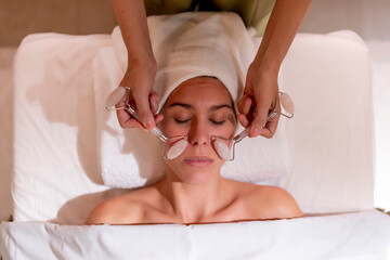 Young female customer receiving spa treatment from massage therapist