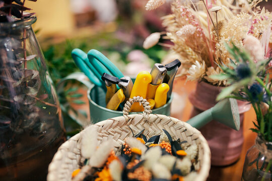 Gardening tool and flowers kept on table at flower shop