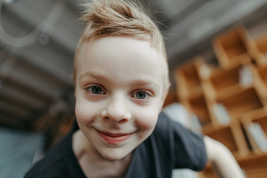 Close-up portrait of smiling blond boy at home