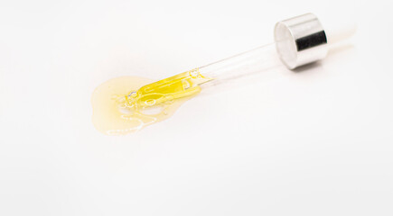 Close-up of a face serum on a white background. Collagen, hyaluronic acid for skin care. pipette with golden serum on a surface