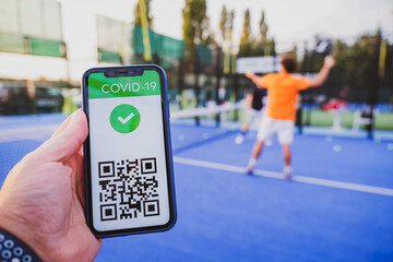 Man showing vaccination certificate covid-19 with app on smartphone first to do sport, coronavirus...