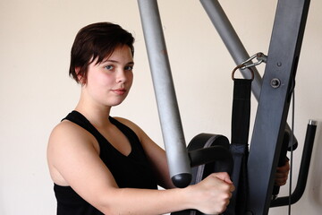 Fototapeta na wymiar A young woman training on an exercise machine