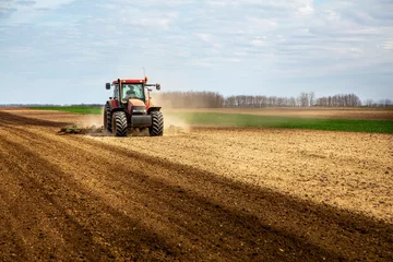 Photo sur Plexiglas Tracteur Farmer in tractor plowing field in spring