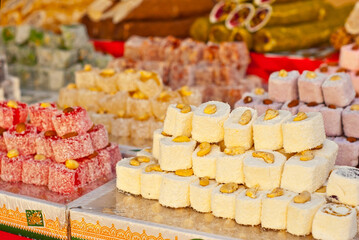 Turkish national sweets are sold at the fair. Multi-colored Asian desserts stacked on the table. Rahat lokum in bulk is sold at the festival.