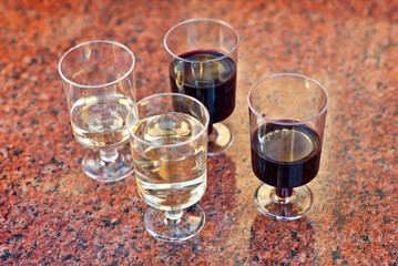 Plastic glasses with wine close up. Different types of wine on a marble table.