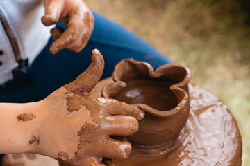 A child makes a jug of clay on a potter's wheel