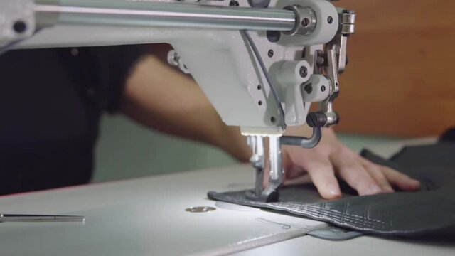 Seamstress Sews Leather Parts On An Industrial Sewing Machine. Professional Sewing Equipment. Close-up.