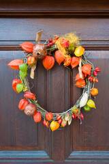 Herbstkranz auf Holzhaustür als Symbol für die Jahreszeit Herbst