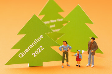 Toy men made of plastic and Christmas trees made of paper with text on a colored background, a concept on the topic of quarantine for the new year
