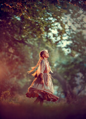 Girl with braids in beige clothes is spinning in the autumn forest