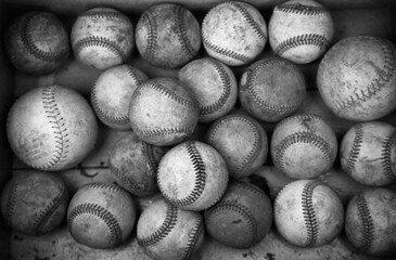 a lot of old dirty baseballs in a box