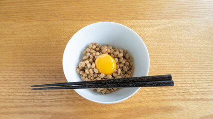 日本の納豆と生卵。皿の上に箸。