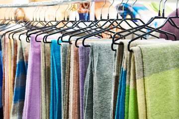 Warm woolen plaids on hanger in store