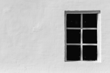 Old vintage window on a white stone wall.