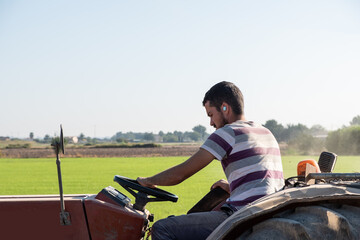 young farmer plowing with a tractor while listening to music © aglcharro