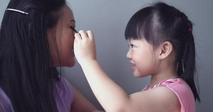 4K Video slow motion Asian little daughter doing make up her mom. Concept of love and connection of mother and kid.
