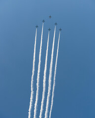 青空に５本の飛行機雲を作る飛行機隊