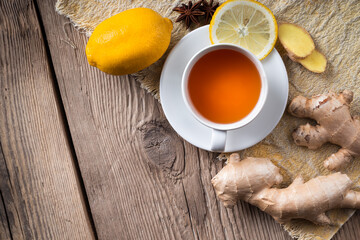 Ginger tea with lemon on wooden background