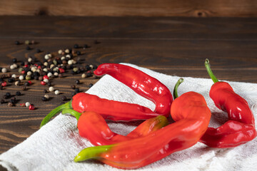 Red chilli pepper with black and white peppercorns on wooden background. With Copyspace
