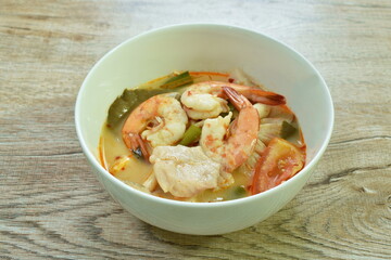 boiled river shrimp and bass fish with mushroom in Thai spicy soup or tom yum kung on bowl
