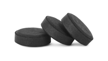 Activated charcoal pills on white background. Potent sorbent