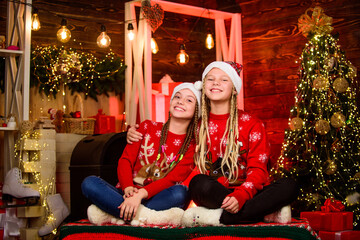Obraz na płótnie Canvas Just look at that. They love Christmas. merry christmas. children having fun. happy small girls at fireplace. New 2020 Year is coming. sisters spend family holiday together. Thank you dear santa