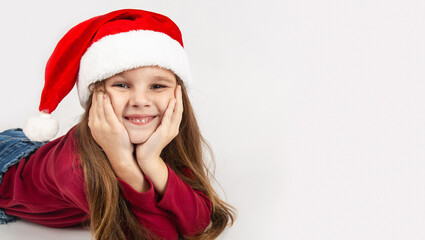 Beautiful little girl with Christmas hat waiting for Santa Claus with a smiling isolated white background. Space for text.