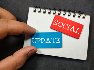 Notebooks and colored wooden board with the word social update.
