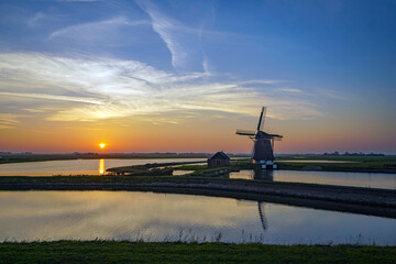 Fototapeta premium Zonsondergang bij de Molen van het Noorden op Texel