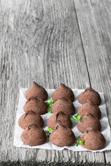 Homemade chocolate truffles with cocoa powder on wooden table