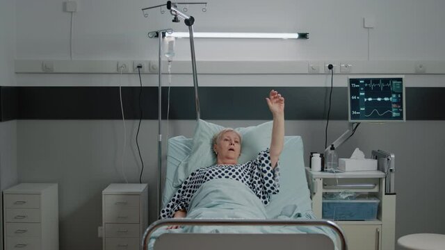 Doctor and nurse using oxygen tube and oximeter on ill patient breathing heavily in bed. Medical team helping senior woman to cure respiratory problem with equipment and tools.