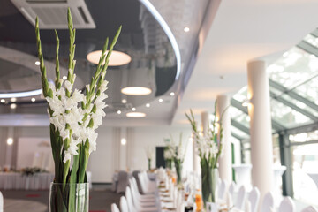 Celebration concept Laid tables in lobby of restaurant or hotel await guests. Tablecloths. No people.