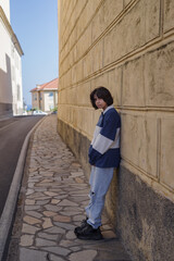 Teenage girl standing by wall