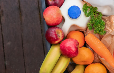 food box delivered and ordered online, milk, vegetables, eggs in a box parcel sent home, groceries delivery, online food order and delivery concept. 