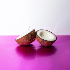 Creative tropical fruit and summer composition with coconut on shiny purple background. Minimal exotic concept.