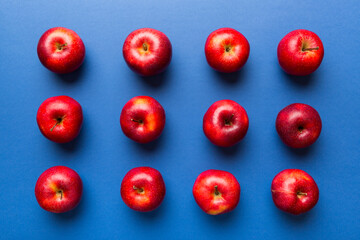 Many red apples on colored background, top view. Autumn pattern with fresh apple above view