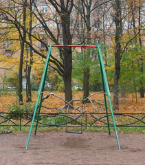 Fototapeta na wymiar Colorful children's swing on the playground in autumn