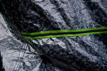 Silver car windscreen cover with rope on gray canvas background. Travel and protection from radiation concept. Silver car windscreen covering with shadow