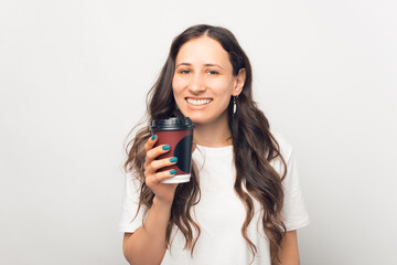 Naklejka premium Happy smiling woman is holding a take away paper cup of coffee.