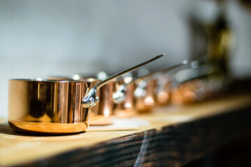 Small copper pots on a wooden ledge at a restaurant